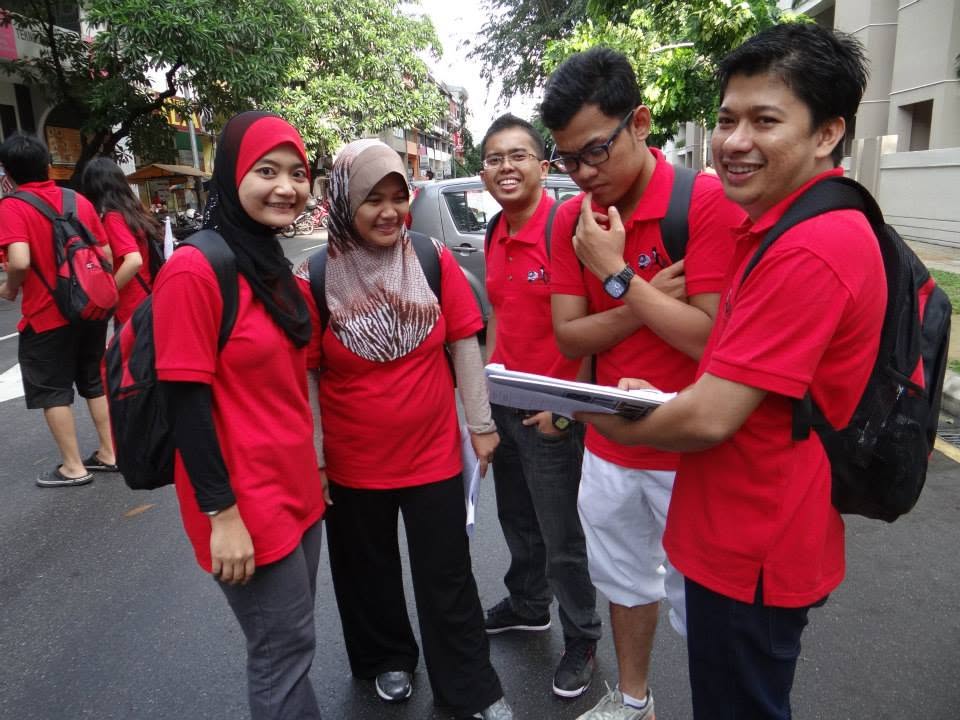 Team in red shirts completing a rope challenge